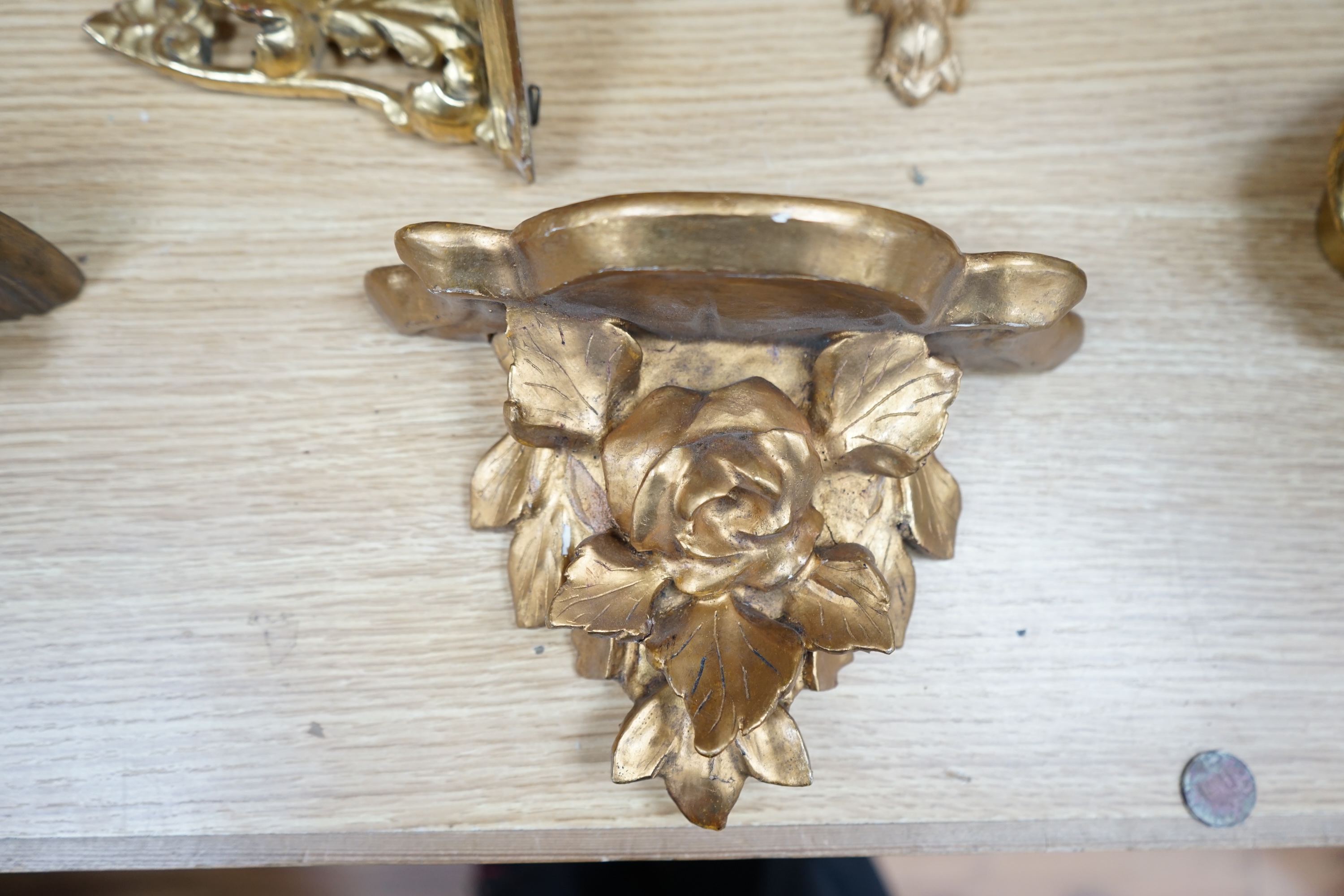 A pair of gilt painted wall brackets, three others, a pair of oval mirrors, plus another and two gilt metal vase holders. Pair of wall brackets 19.5cm high. Condition - wall brackets and mirrors fair to good, vase holder